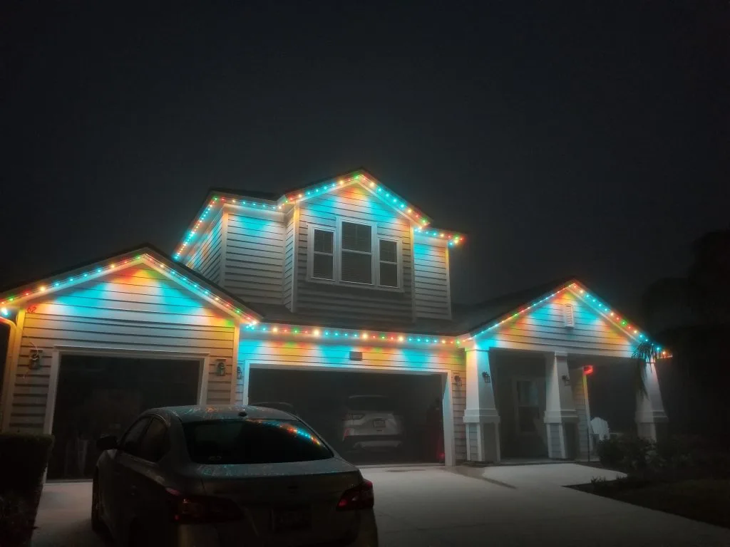 Roofline lighting in St. Augustine brightens a house with colorful lights in a foggy setting
