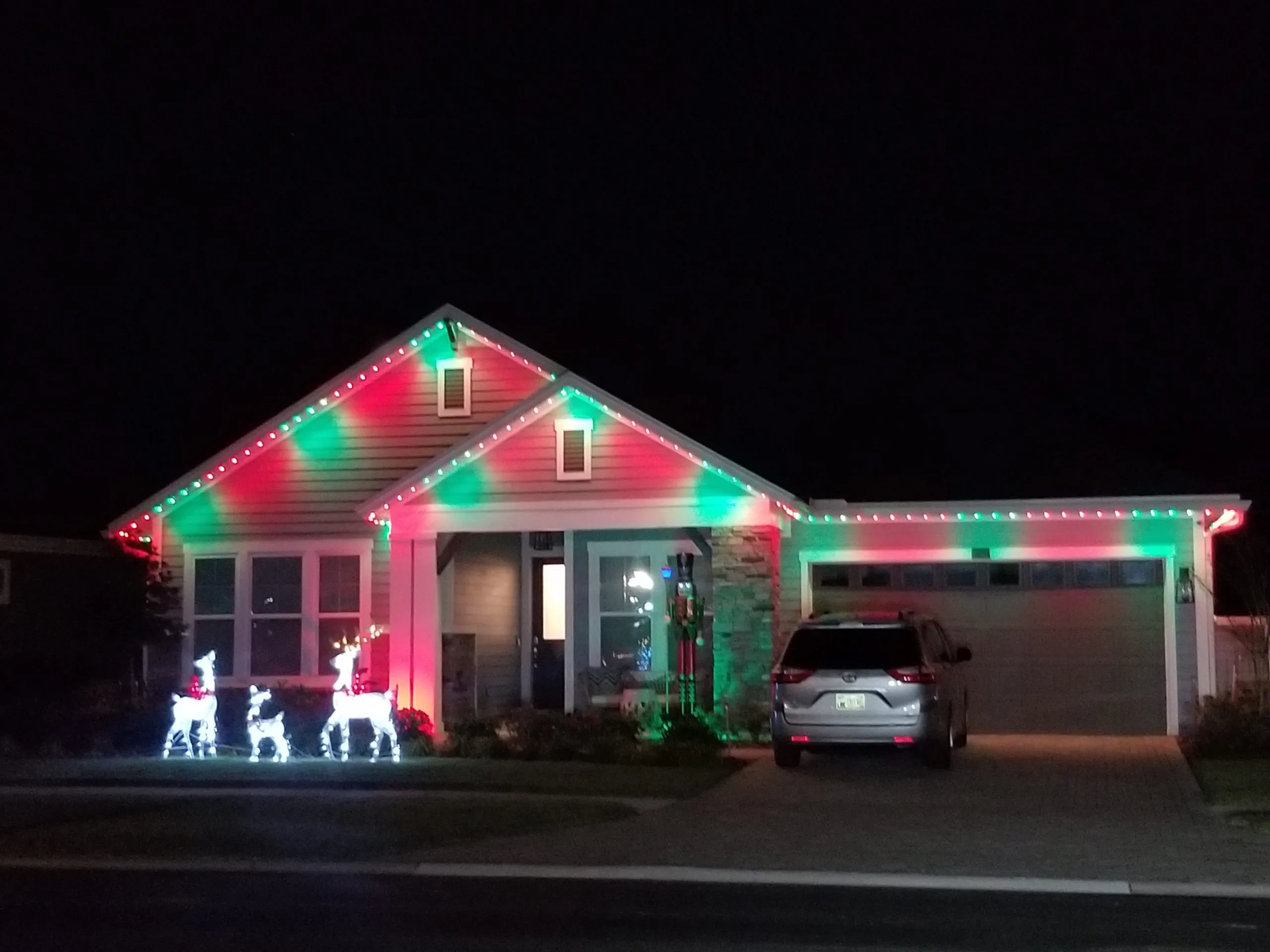 Permanent lighting in Jacksonville enhances a house with vibrant red and green holiday decorations
