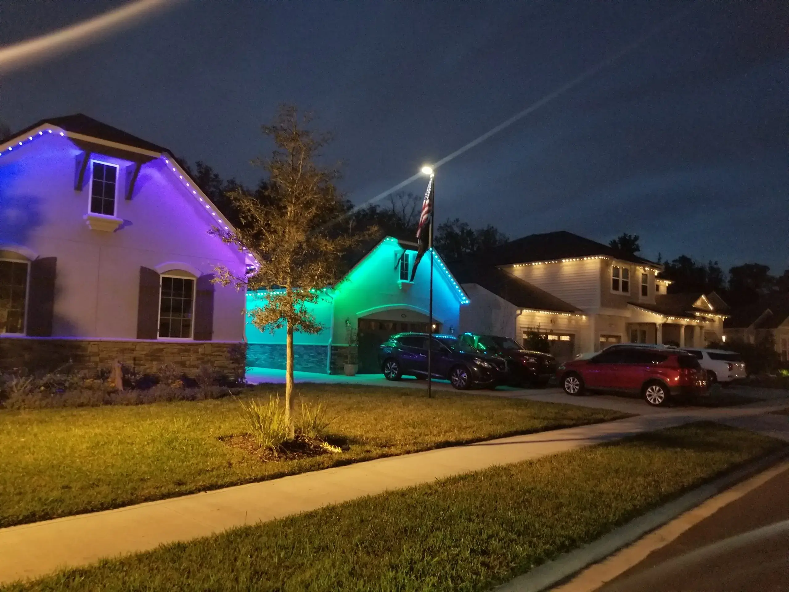 Colorful lights illuminate homes at night, creating a festive atmosphere