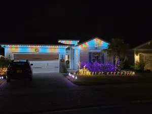 Trim lighting enhances the festive decorations of a well-lit house at night