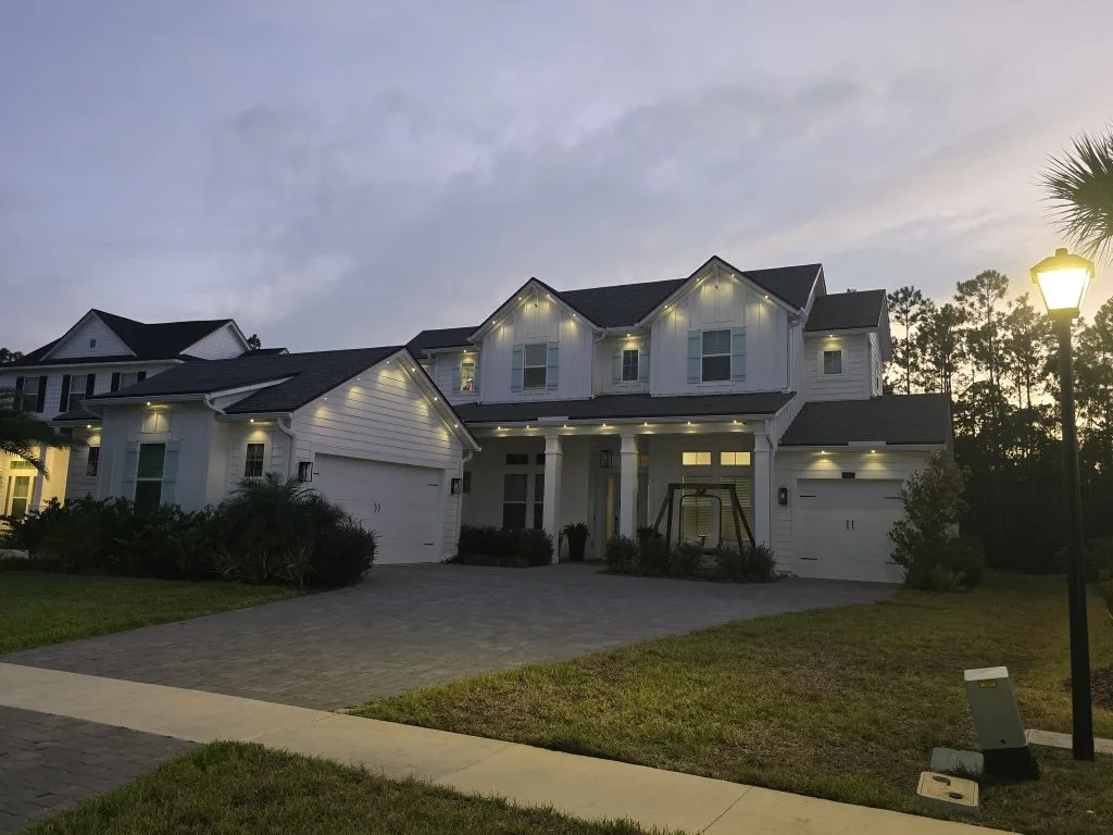 Outdoor lighting in Jacksonville enhances the elegance of a well-lit house at twilight