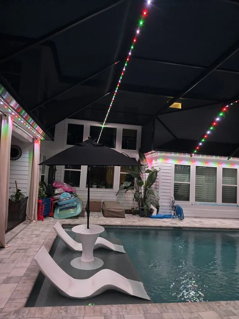 Pool cage lighting creates a serene atmosphere in the illuminated pool area
