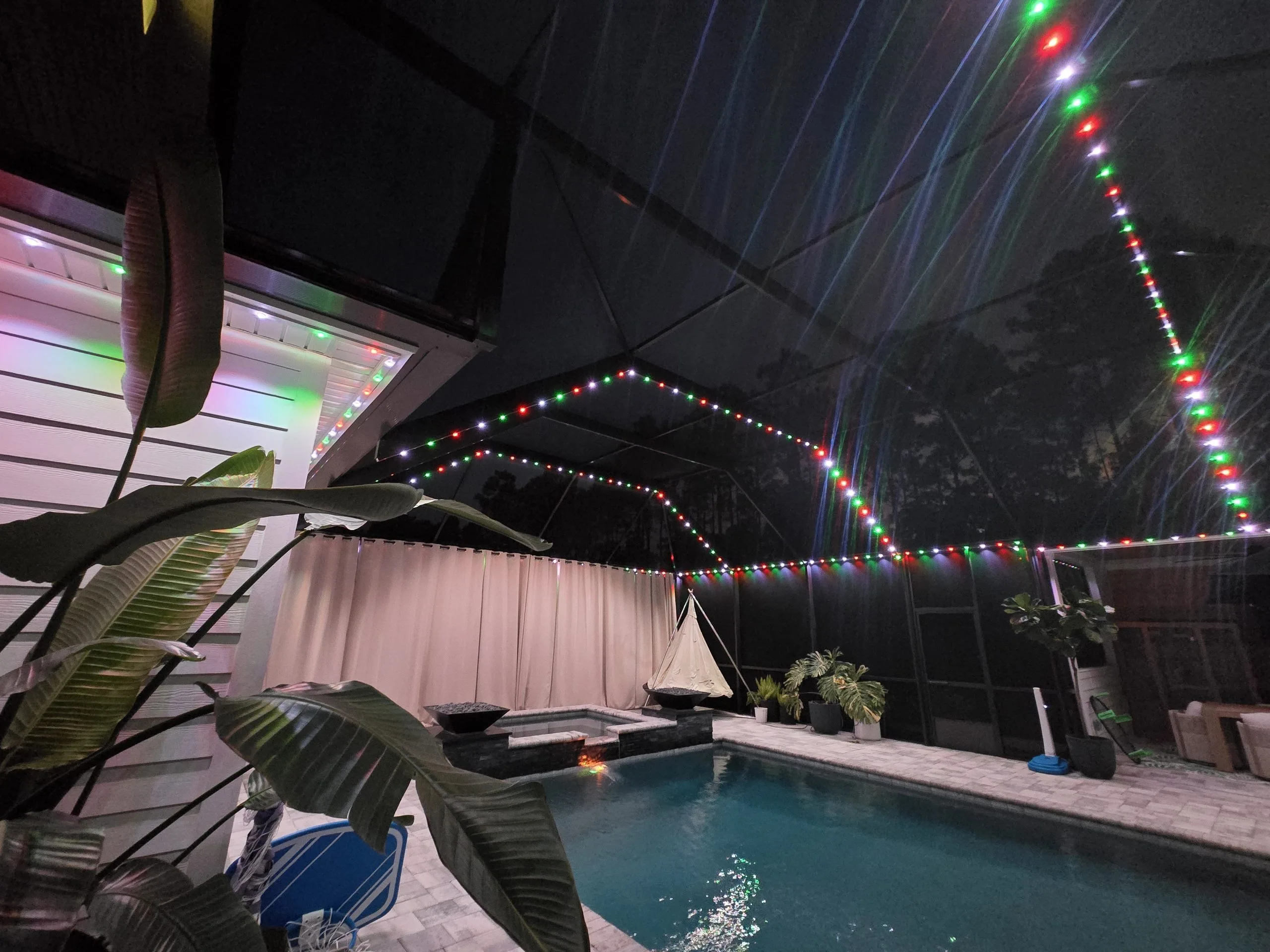 A tranquil pool area illuminated by colorful lights in a serene nighttime setting