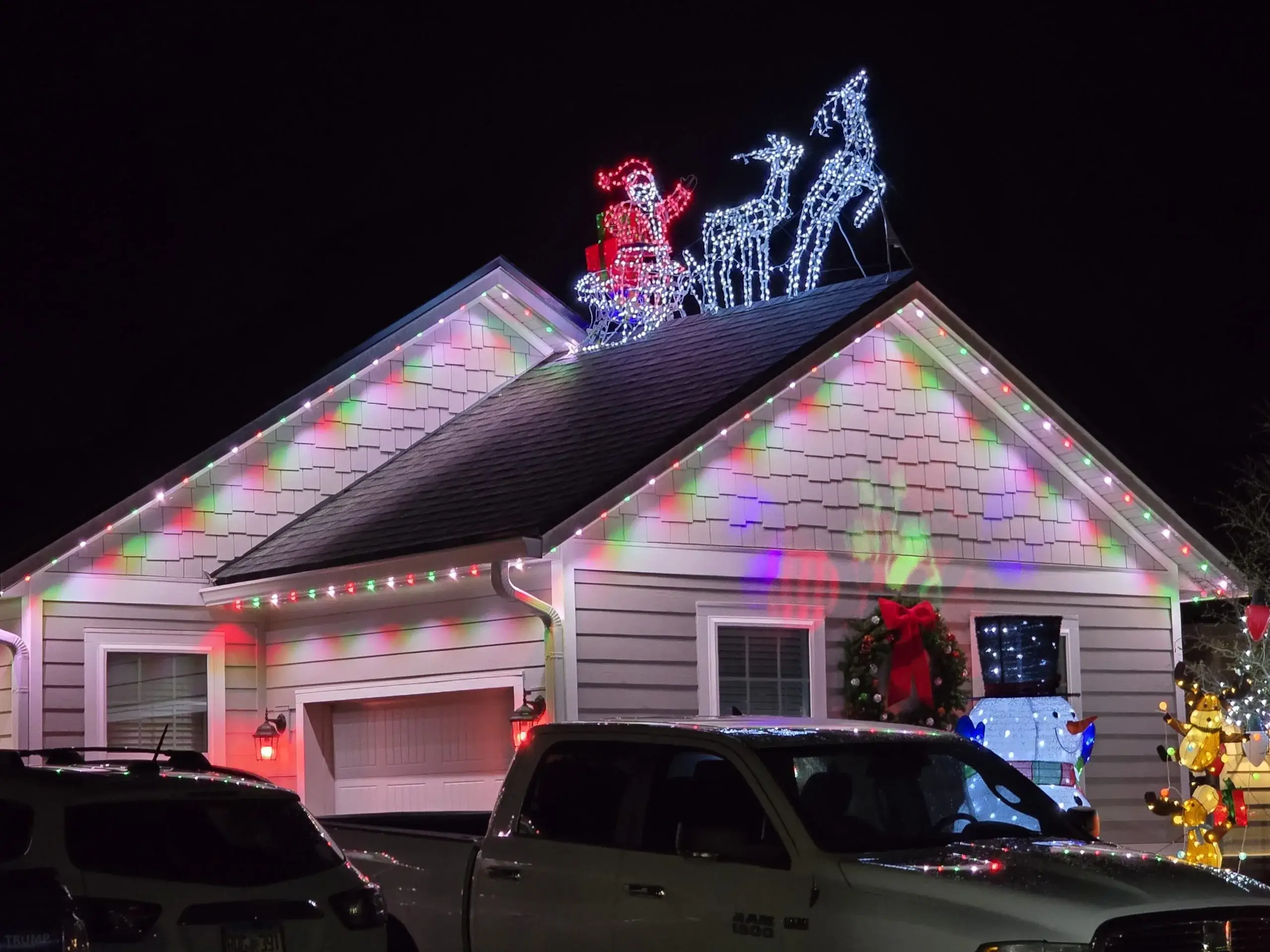 Permanent lighting in Jacksonville enhances a festive house with bright lights and a sleigh on the roof