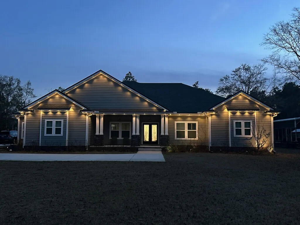 A charming house is adorned with warm, glowing lights as dusk settles